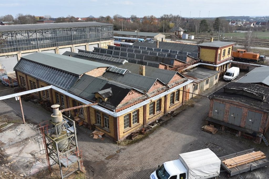 Diese Luftbildaufnahme zeigt im Vordergrund die Spezialgewerkehalle mit Dreherei.
