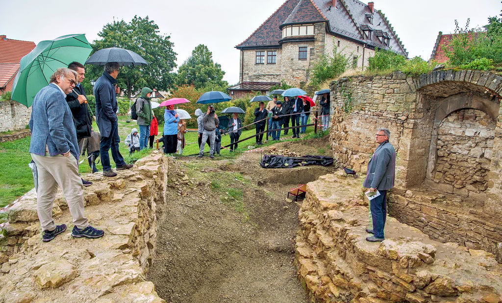 Grabungsstelle Vorhof Neuenburg: Im Regen stellen Landesarchäologe Harald Meller (l.) und Donat Wehner, Projektleiter beim Landesamt für Denkmalpflege und Archäologie Sachsen-Anhalt, der Öffentlichkeit den Sensationsfund vor - die aufgehenden Mauern eines achteckigen Turms.