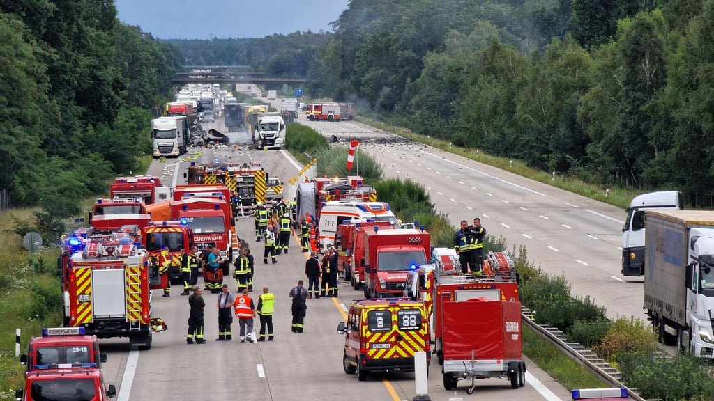 Helfer stehen an einer Unfallstelle.