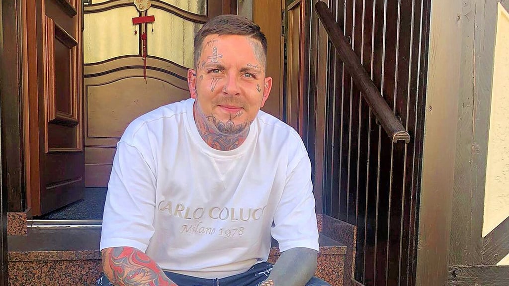 Tobias Keck ist Eigentümer des Tattoo Studios UnderSkin in Burg, hier sitzt er vor dem Eingang seines Studios.