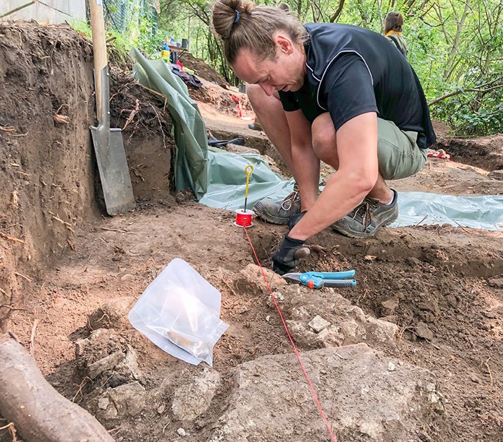 Student Marcus Petereit legt bei Quedlinburg Steine frei, die vermutlich zu einem Galgenpfosten-Fundament gehören.