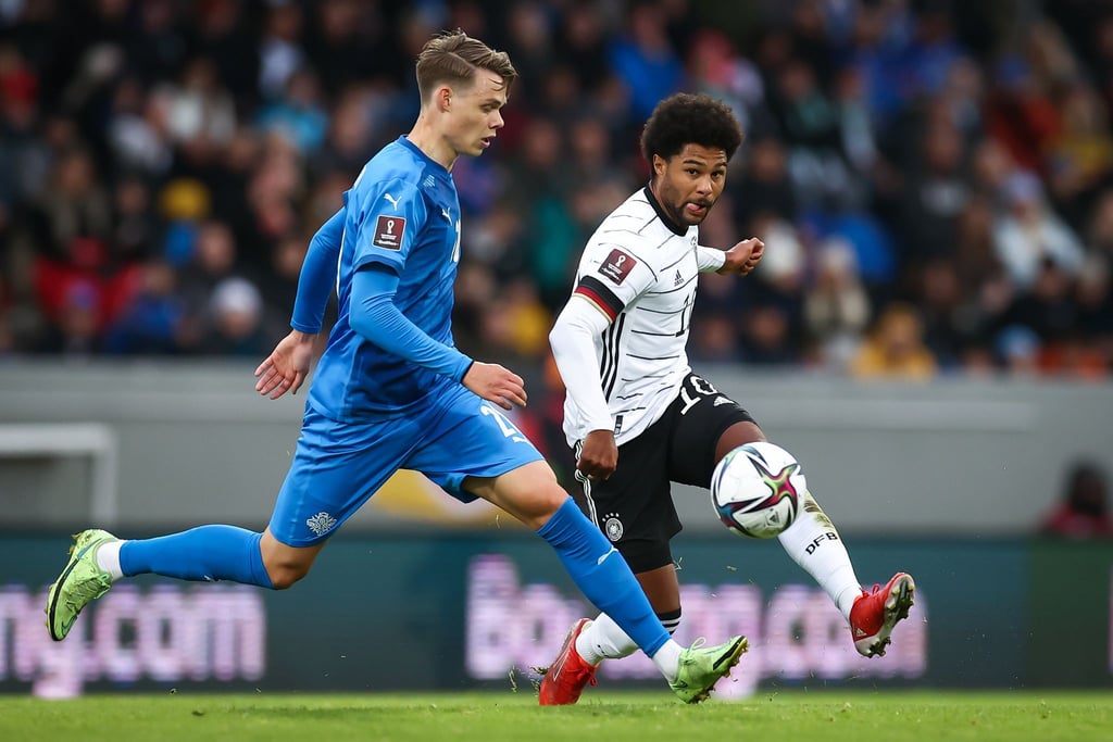 Thorir Johann Helgason (l) aus Island und Serge Gnabry aus Deutschland im Kampf um den Ball.