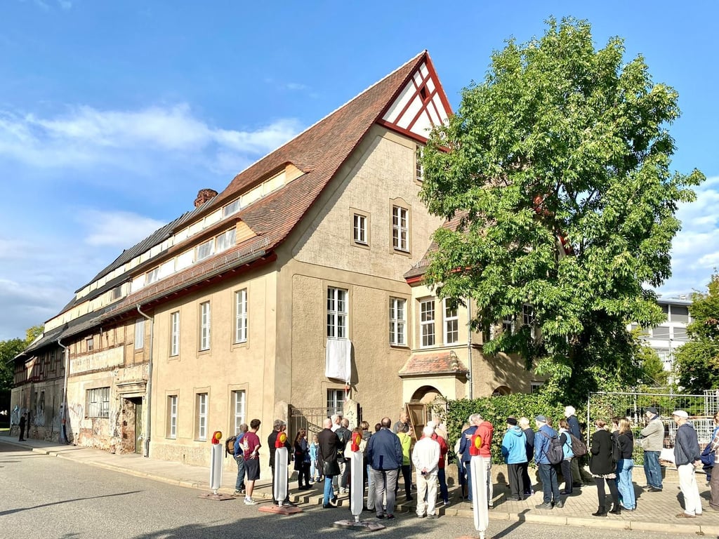 Viele interessierte Hallenser verfolgen die feierliche Enthüllung des neuen Sandsteinreliefs an der Südseite der Schwemme-Brauerei.