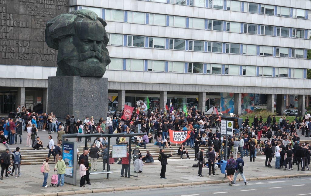 Teilnehmer einer linken Demonstration versammeln sich am Karl-Marx-denkmal.