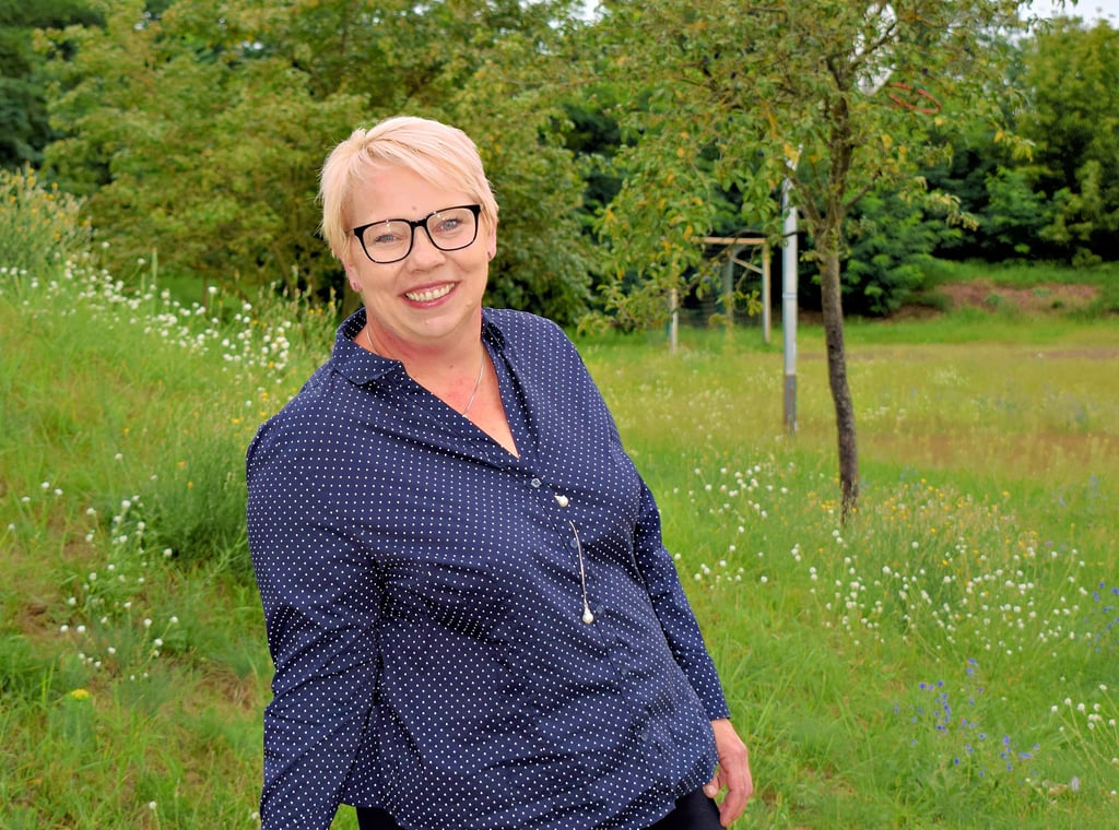 Ina Möbius aus Gerwisch kandidiert für die CDU als Biederitzer Bürgermeisterin. Im Hintergrund ist der Bolzplatz an der Lostauer Straße in Gerwisch zu sehen, für den sie sich für die Zukunft eine Entwicklung wünscht.