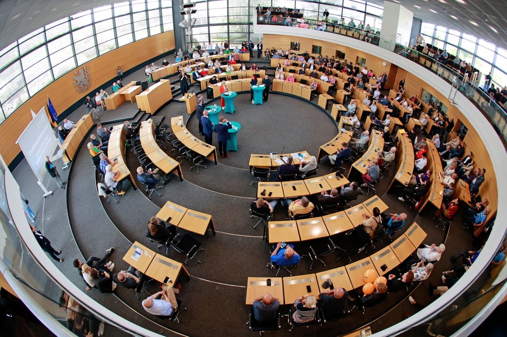 Besucher nehmen im Plenarsaal an einer Diskussionsrunde mit den Fraktionsvorsitzenden der Parteien teil.