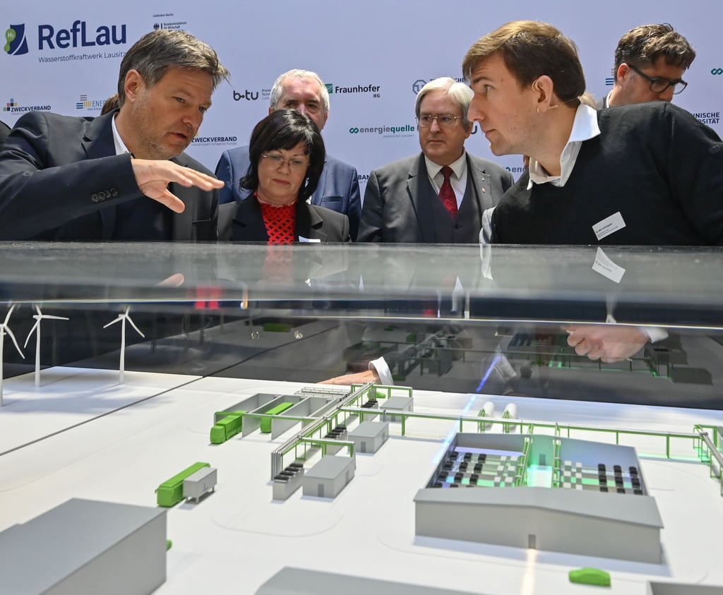 Robert Habeck (l) informiert sich über das Modell des künftigen Wasserstoff-Referenzkraftwerkes Lausitz im Industriegebiet Schwarze Pumpe.