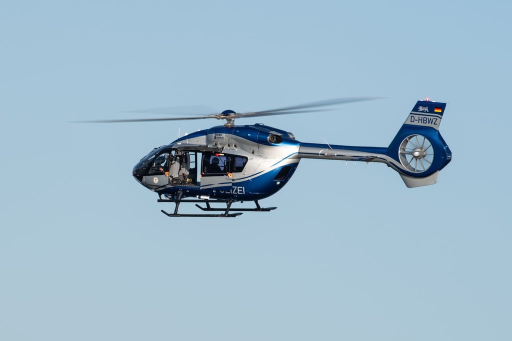 Ein Polizeihubschrauber fliegt im Rahmen eines Trainings über ein Gewässer.