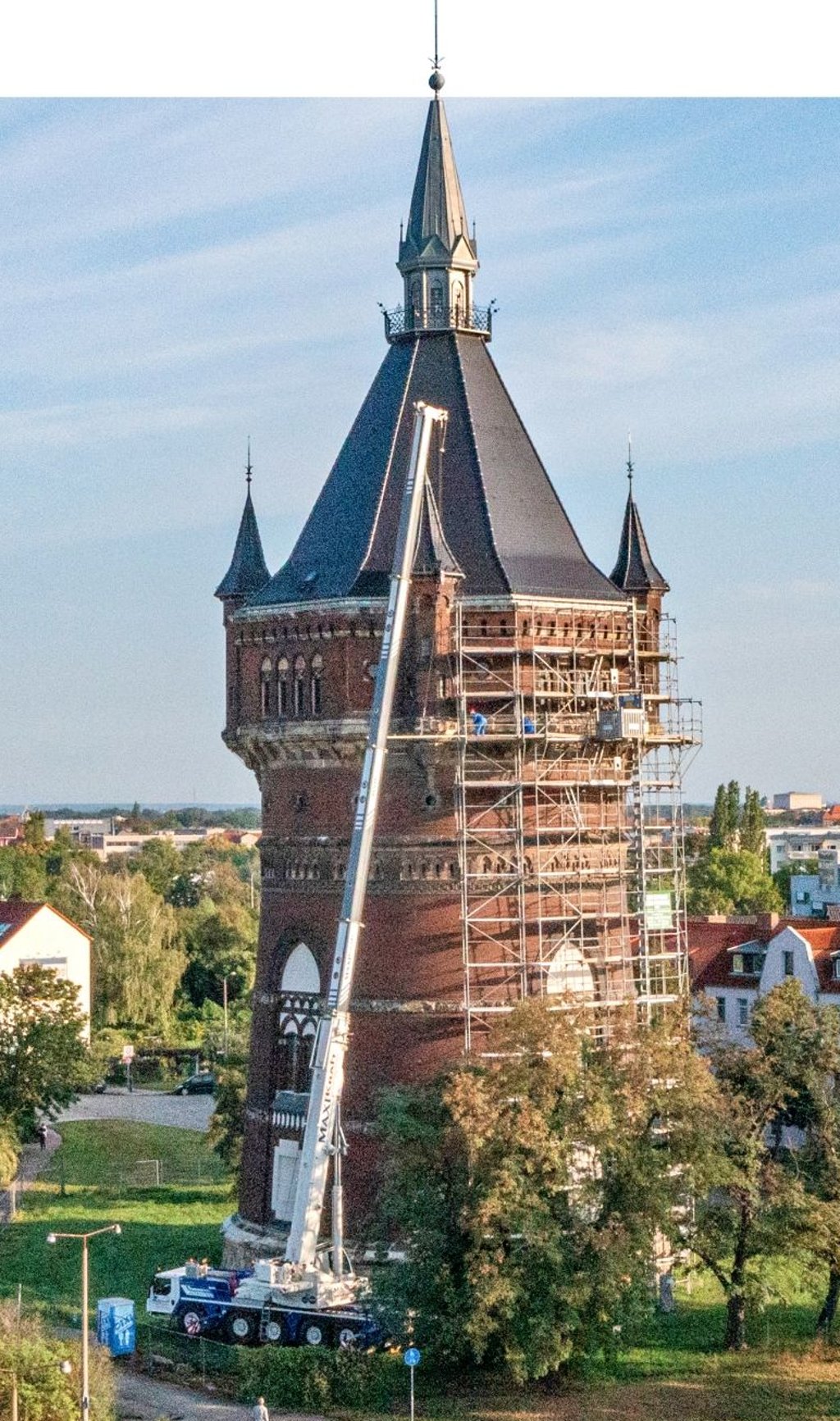 Am Neuen Wasserturm in Dessau ein Riesenkran sperrige Behelfträger rund 30 Meter nach oben, um die Sanierungsarbeiten am Hauptsims beginnen zu können.