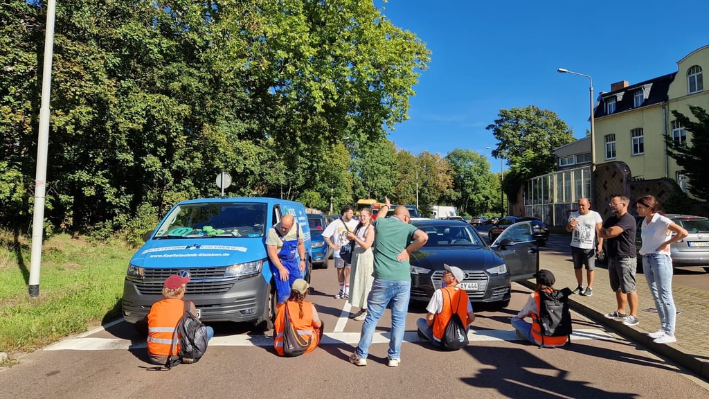 Aktivisten der Letzten Generation blockieren die Paracelsusstraße am Zoo Halle.  