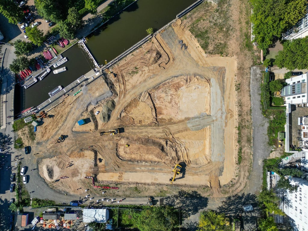 Bagger und Baufahrzeuge stehen auf dem Gelände des zukünftigen Hafenbeckens des Stadthafens Leipzig.