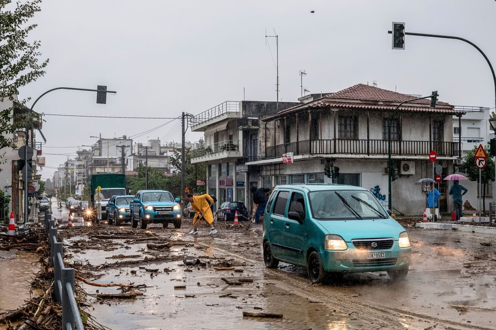 Ein Mann säubert die Straße nach dem Hochwasser in Volos.