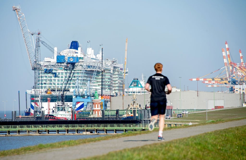 Ein Jogger läuft auf dem Weserdeich in Richtung des Kreuzfahrtterminals Columbus Cruise Center.