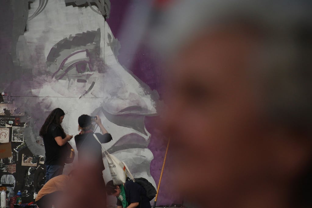 Ein Wandgemälde mit dem Bild des kommunistischen Sängers Victor Jara ist am Park Baquedano zu sehen.