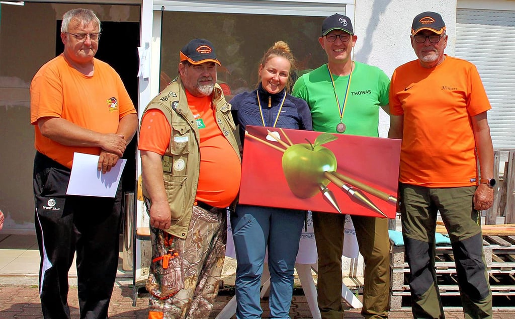 Der stellvertretende Vorsitzende der Burgschützen, Thomas Waßerberg und der Vorsitzende, Heiko Block (v.l.) sowie Hubert Vollroth (r.) überreichten Sabine Leinung und Thomas Scheunemann von Bogensport Bördeland ein großes Bild als Anerkennung für die Eröffnung ihrer Bogenhalle in Biere.