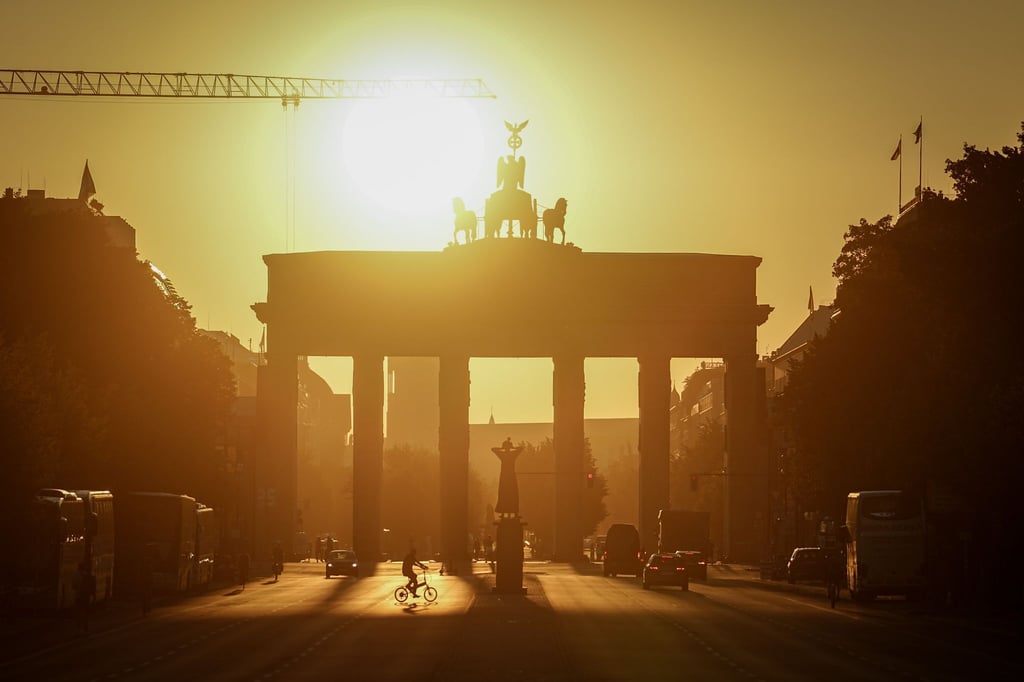 Die Sonne geht am frühen Morgen hinter dem Brandenburger Tor auf.