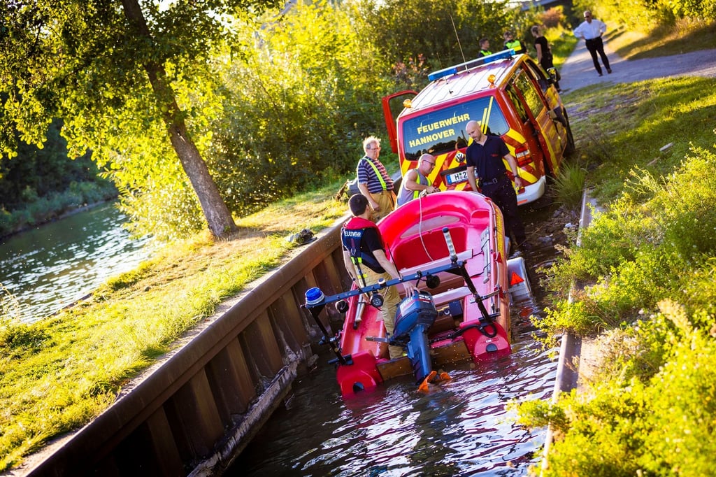 Einsatzkräfte der Feuerwehr ziehen ein Feuerwehrboot aus dem Mittellandkanal in Hannover-Vinnhorst.