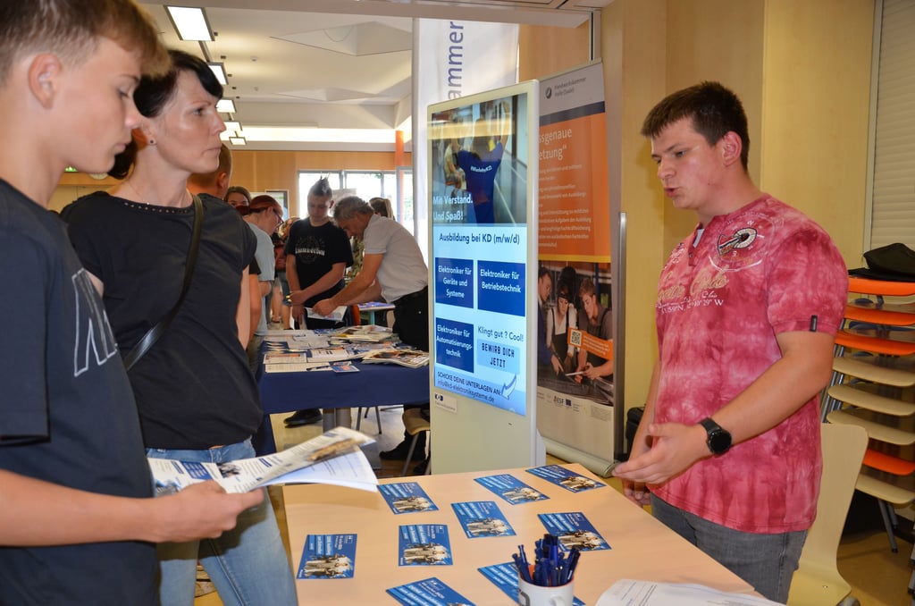 Merlin Malcher (r.) absolviert bei der Zerbster Firma KD Elektroniksysteme GmbH gerade eine Ausbildung zum Elektroniker. Was diese beinhaltet und andere Frage beantwortete er interessierten Schülern und Eltern gern.