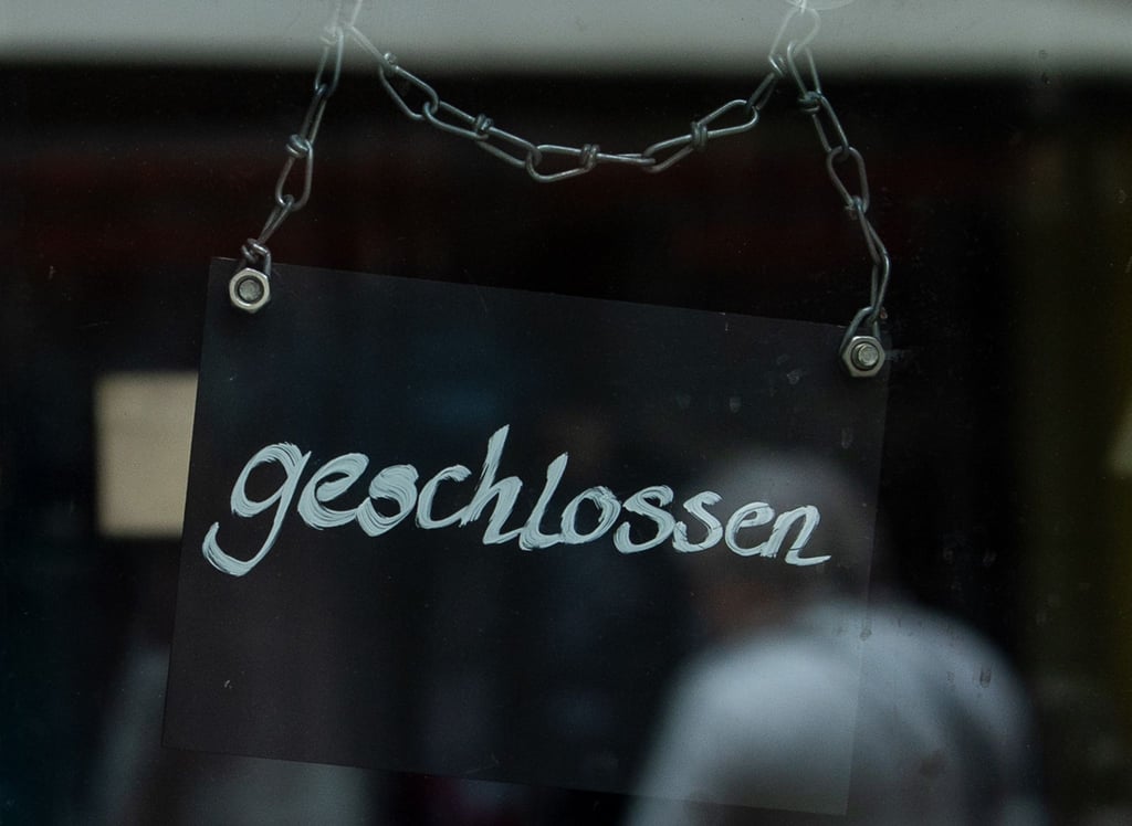 An einem Café hängt ein Schild mit der Aufschrift „geschlossen“.