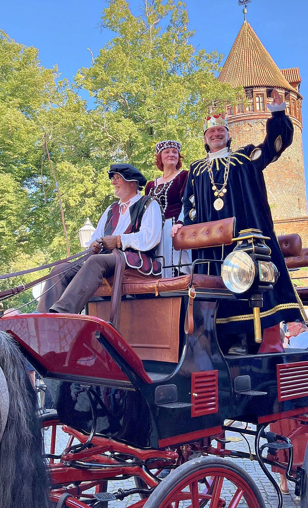 Von dieser hohen Kutsche aus grüßen Kaiser Karl IV. (Rüdiger Albrecht) und dessen Gemahlin (Anne Birkholz) das Volk beim Einzug in die Stadt.