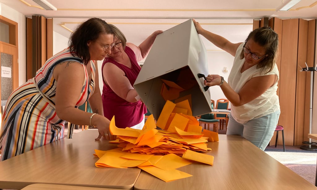 Cornelia Towara, Anke Greßler und Katja Storm (von links) kippen die Wahlurne im Wahllokal in Osternienburg aus.