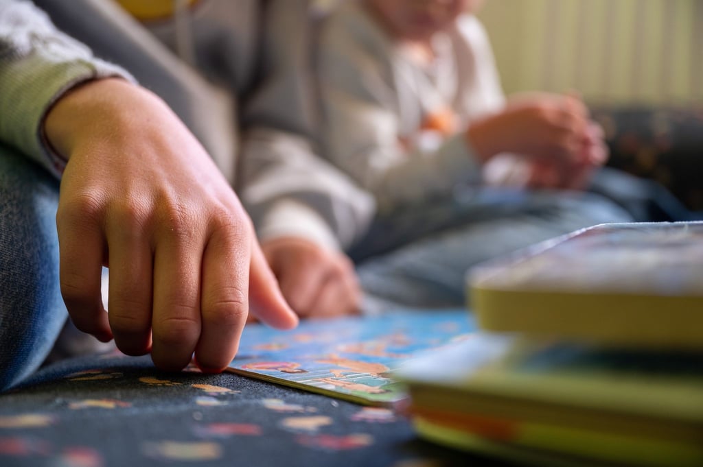 Eine Praktikantin liest in einer Kita Kindern vor.