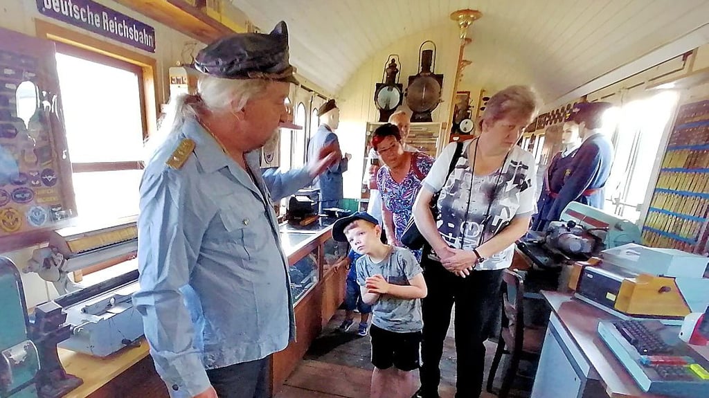 Vereinschef Roman Neunherz (l.) führt beim verkehrshistorischen Wochenende durch die „mobile Ausstellung“.
