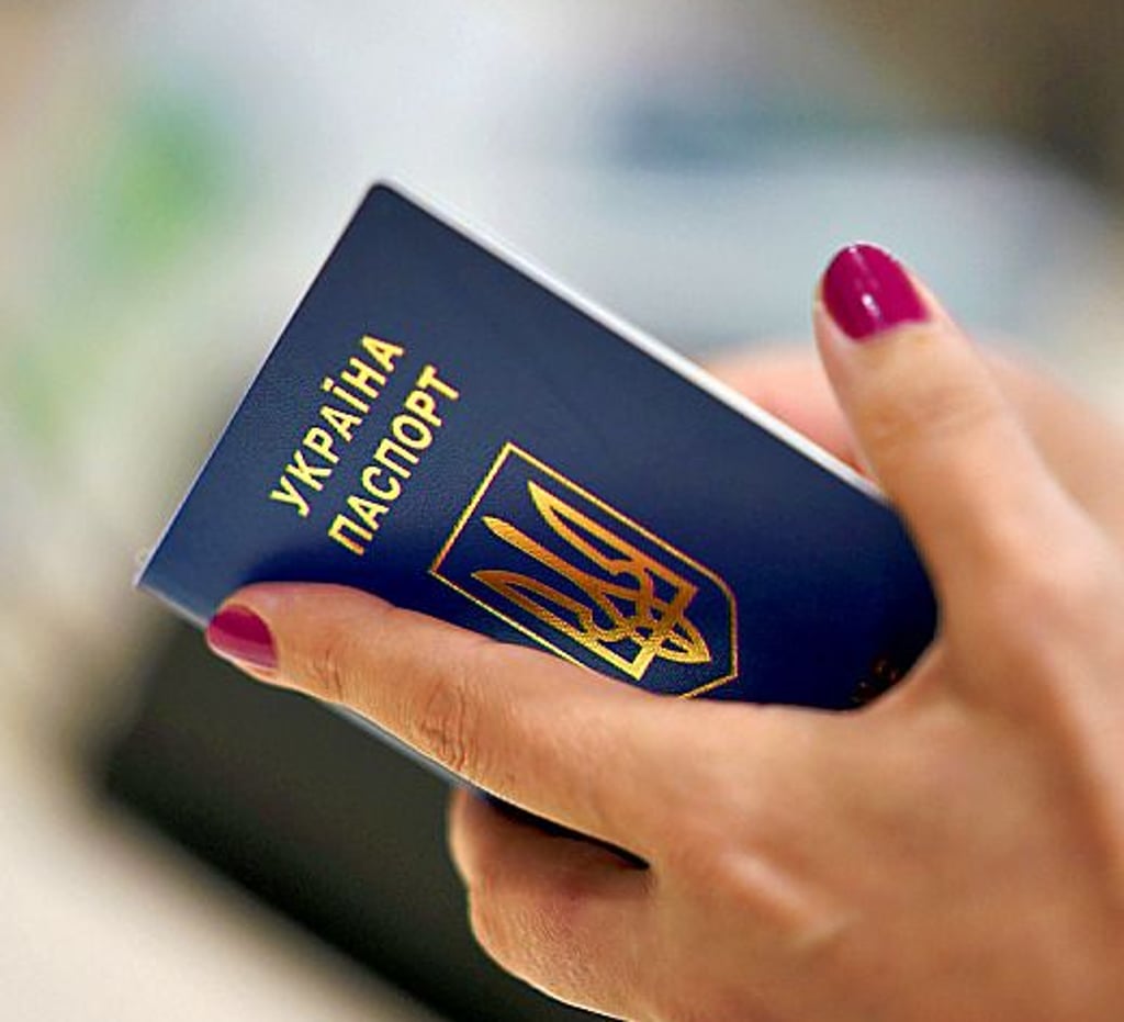 Eine ukrainische Frau hält ihren Reisepass in der Hand.