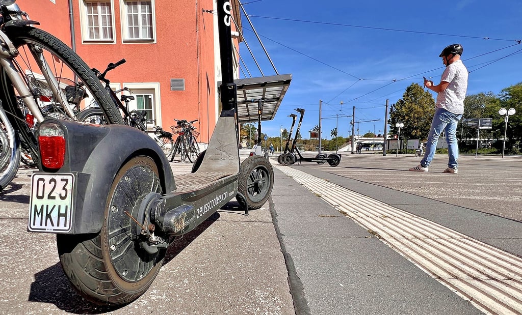 Entsperren und Parken der Roller funktioniert mit einer Handy-App. Vor dem Bahnhof stehen viele der Scooter.