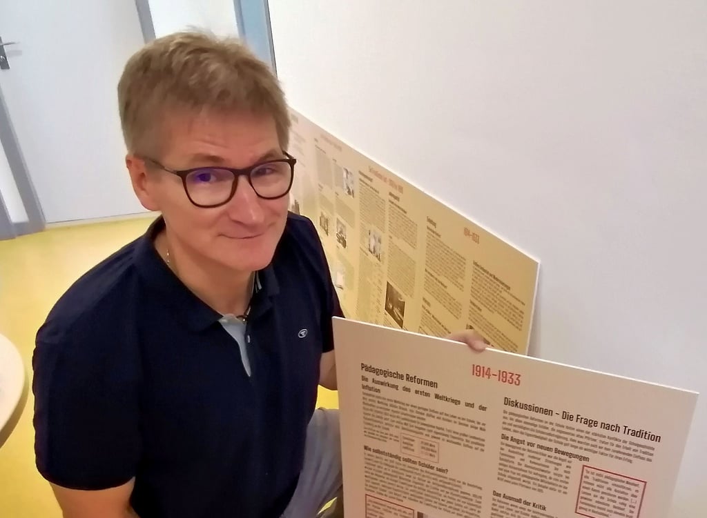 Tutor und Geschichtslehrer Frank Kisser mit einer der zwölf von den jetzt ausgezeichneten Schülern konzipierten Schautafeln. Ebenjene sollen künftig in einer Ausstellung öffentlich zugänglich gemacht werden.