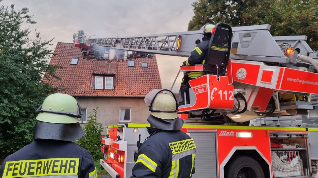 Feuerwehrleute löschen eine Brand in einem Wohnhaus.