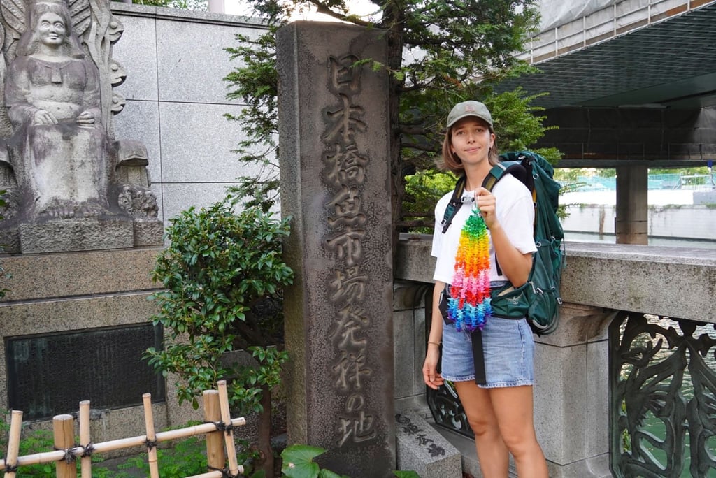 Eva Fritz hält eine Kette aus bunten Papierkranichen in der Hand. Sie will von Tokio aus zweieinhalb Monate lang mit Rucksack und Zelt 1000 Kilometer über Kyoto bis nach Hiroshima wandern.