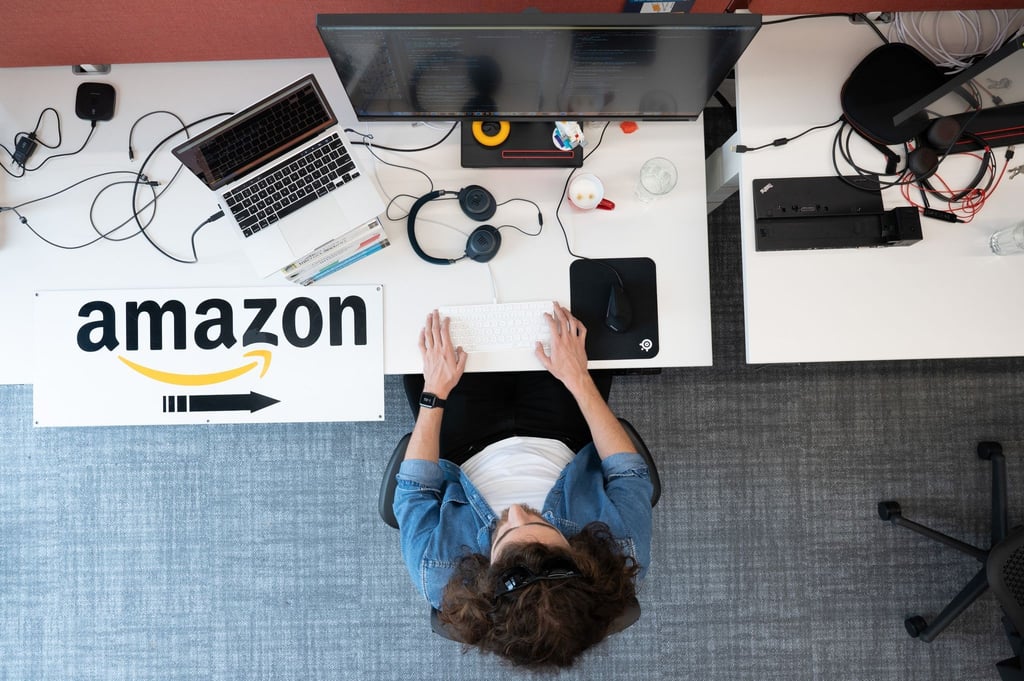 Ein Softwareentwickler von Amazon sitzt am Forschungs- und Entwicklungsstandort an einem Schreibtisch.