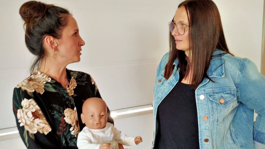 Babylotsin Nadine Wöhlemann (li.), Hebamme an der Helios-Klinik, im Gespräch mit Sandra Gängel, Koordinatorin beim Jugendamt des Kreises MSH, mit „André“ einem Babysimulator, der ebenfalls eine wichtige Rolle bei den Frühen Hilfen in Landkreis Mansfeld-Südharz spielt.