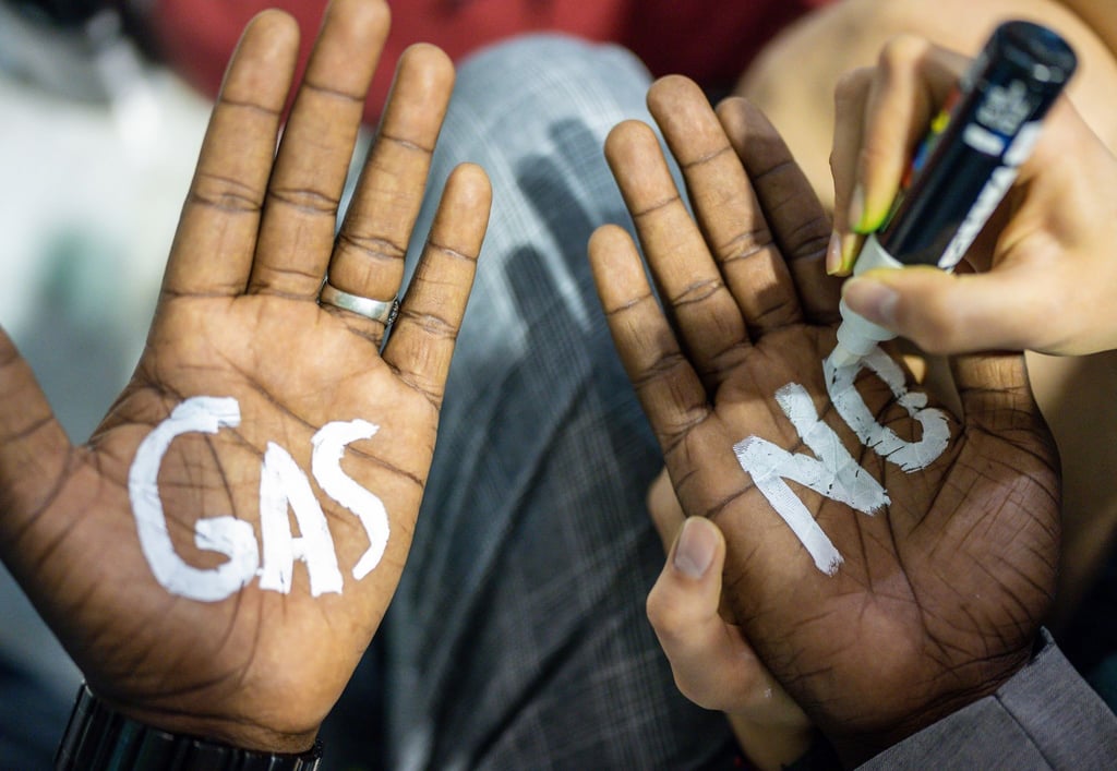 Eine Klimaaktivistin der Fridays for Future-Bewegung schreibt „No Gas“ auf Handflächen.