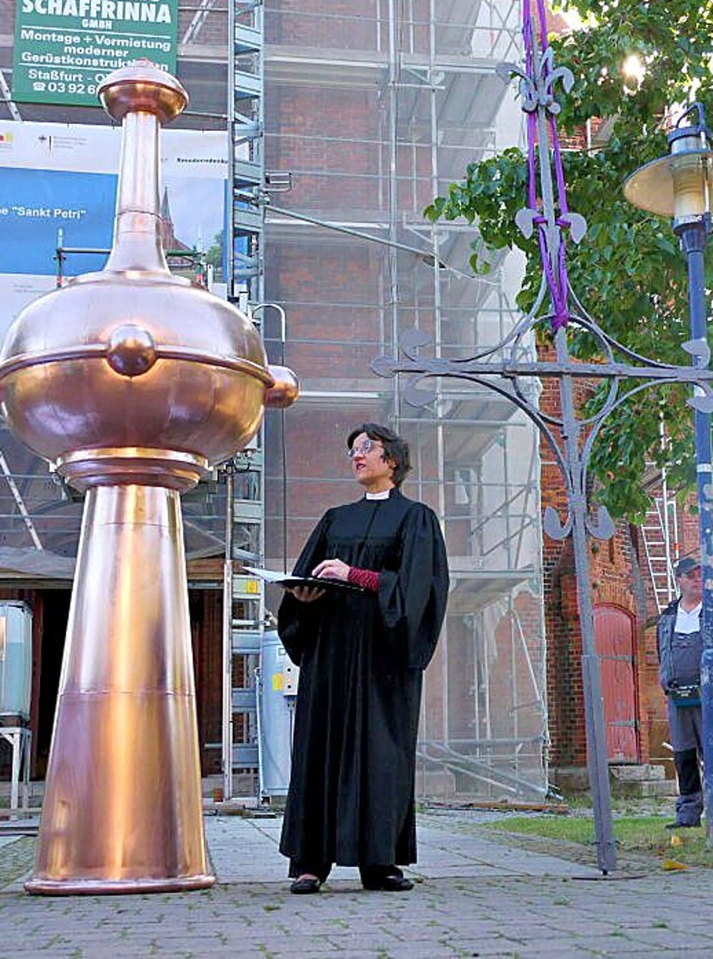 Pfarrerin Michaela Jecht segnet die Bekrönung des Kirchturms.
