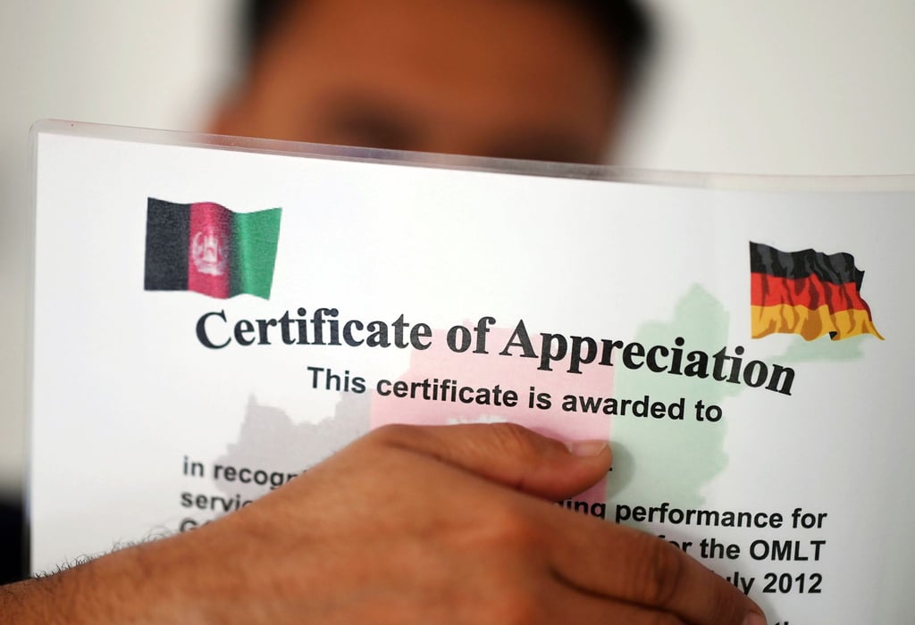 Ein geflüchteter Mann, der als afghanische Ortskraft tätig war, zeigt ein Zertifikat, das nach seinen eigenen Angaben die Zusammenarbeit mit der Bundeswehr in Afghanistan würdigt.