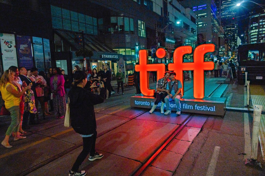 Menschen machen Fotos vor einer Leuchtreklame vor der TIFF Bell Lightbox während des 48. Toronto International Film Festivals.