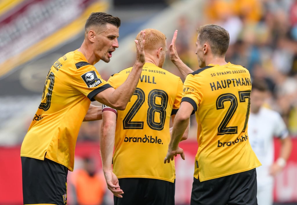 Dynamos Stefan Kutschke (l) klatscht vor seiner Auswechslung mit Niklas Hauptmann (r) ab.