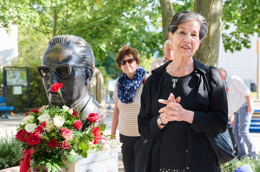 Isabel Allende steht neben der Büste Salvador Allendes.