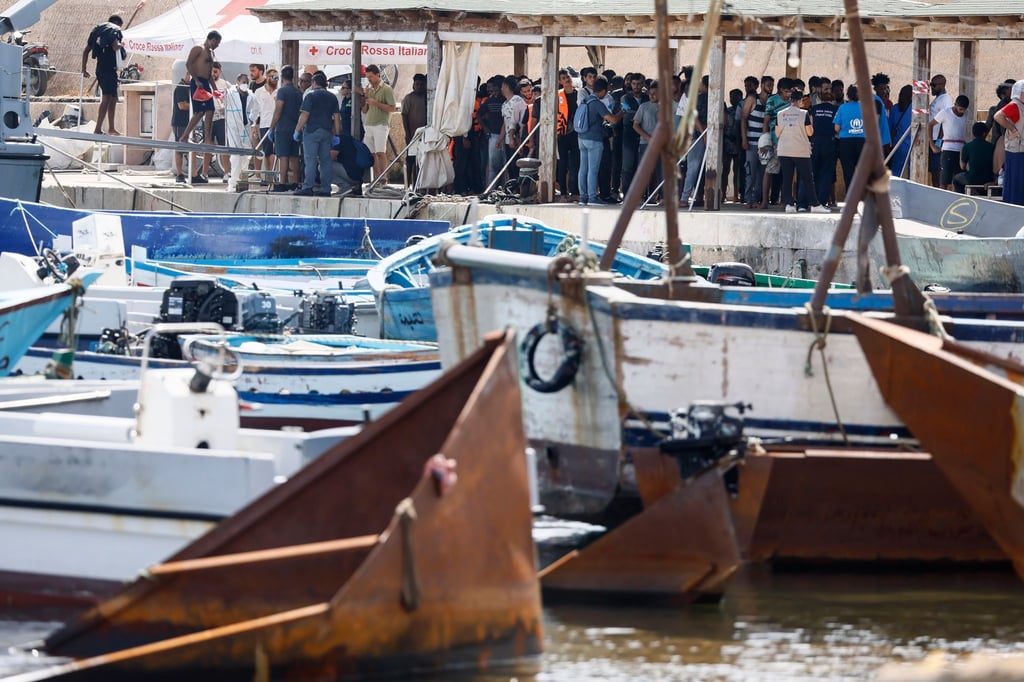 Migranten stehen an einem Hafen auf Lampedusa.