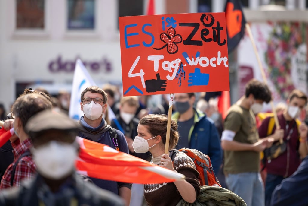 Eine Person hält ein Schild zur Vier-Tage-Woche auf einer DGB-Kundgebung zum 1. Mai in Erfurt.