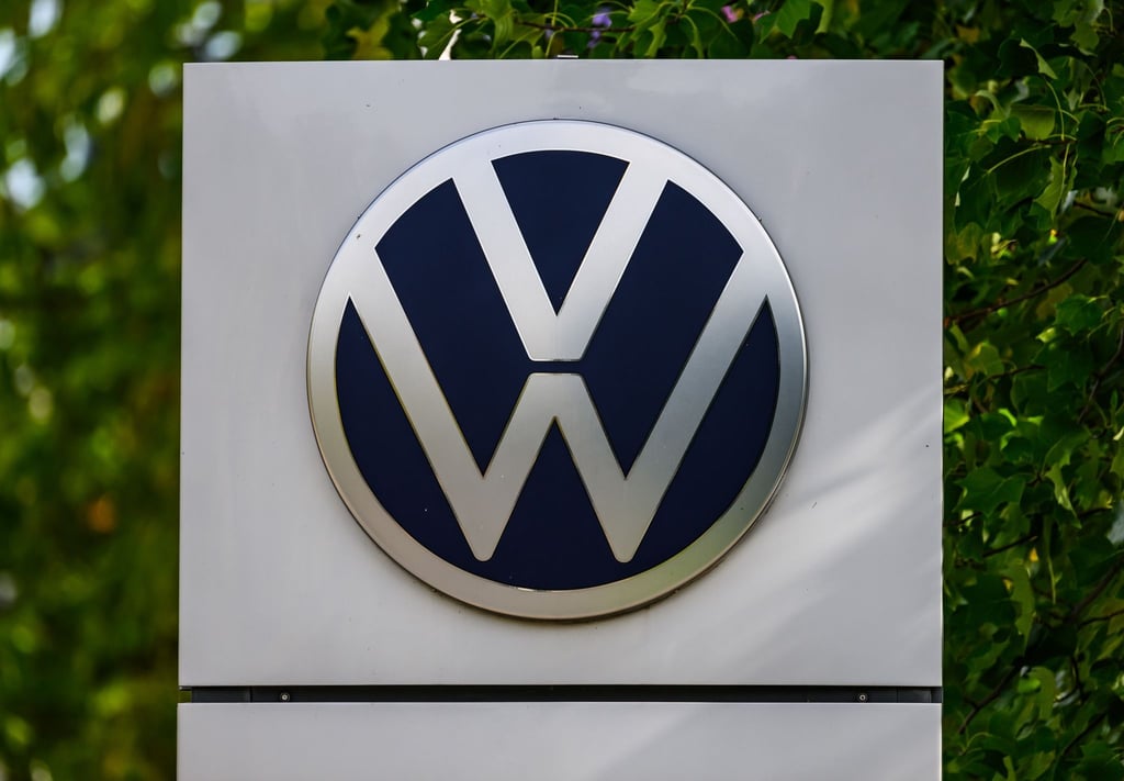 Das Volkswagen Logo ist vor der Gläsernen VW Manufaktur zu sehen.