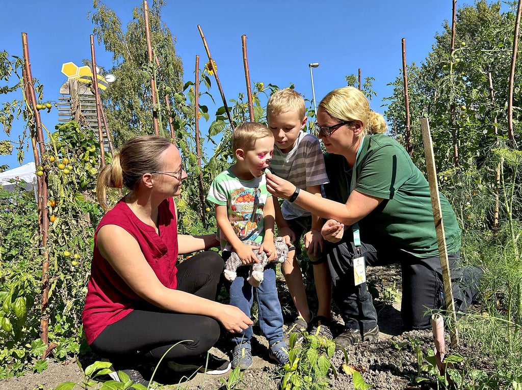 Lena, Julian und Konstantin Sonnenberger gehen mit Steffi Heinrich (v.l.) im Garten auf Entdeckungstour.