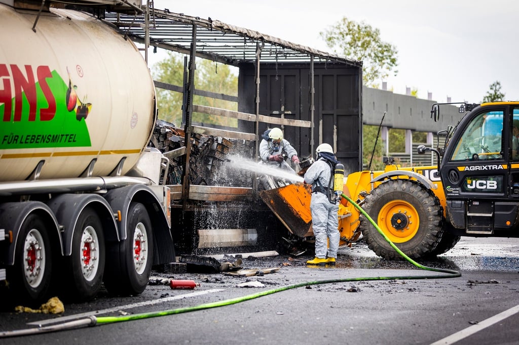 Einsatzkräfte der Feuerwehr löschen die Ladung eines Sattelaufliegers.