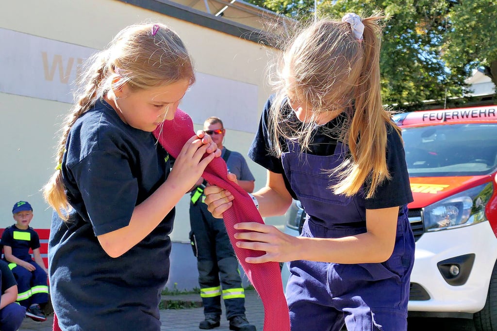 Charlotte (links) und Elayne von der Feuerwehr Ilberstedt haben einen Tennisball durch einen Feuerwehrschlauch geschoben. Dabei wurde die Zeit gestoppt, denn danach wurden die Punkte verteilt.