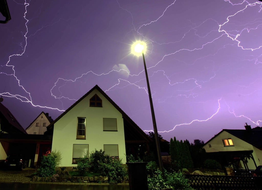 Zahlreiche Blitze sind über einem Wohnhaus zu sehen.