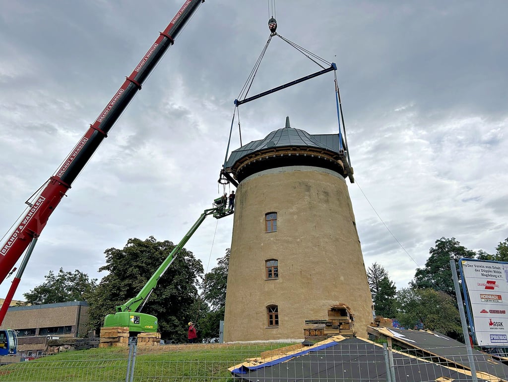 Ein Kran hob den fertigen Drehstuhl, also die Haube, auf die Düppler Mühle in Magdeburg-Olvenstedt. Damit hat der Verein zum Erhalt der Düppler Mühle einen wichtigen Bauabschnitt abgehakt.