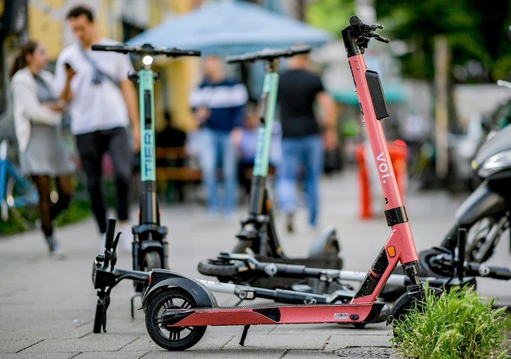 E-Scooter stehen auf einem Gehweg.