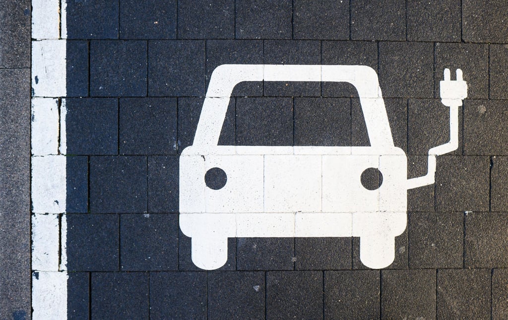 Ein Symbol markiert einen Parkplatz an einer Ladesäule für Elektroautos.
